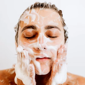 femme qui se nettoie le visage au savon